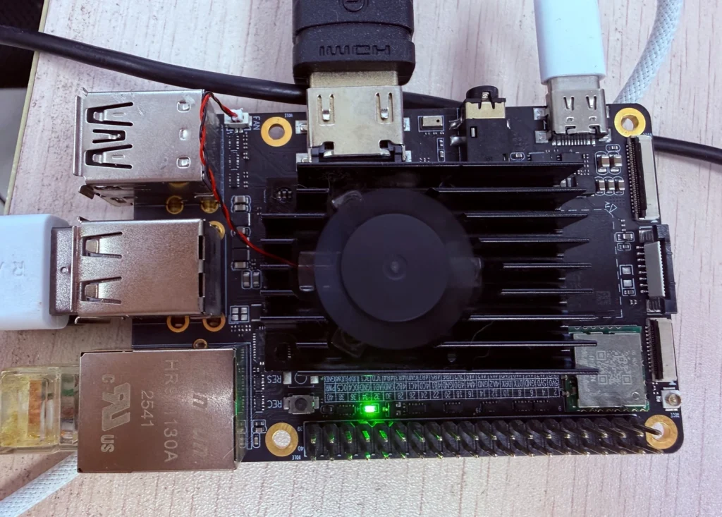 KiwiPi 5 single-board computer with a heatsink, cooling fan and connected cables for the RKLLM experiment